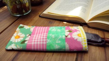 Floral book sleeve pouch with open book on wooden desk