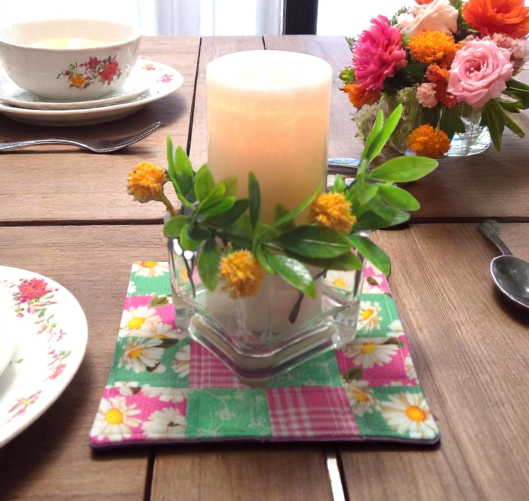 Table setting with patchwork floral placemat and candle