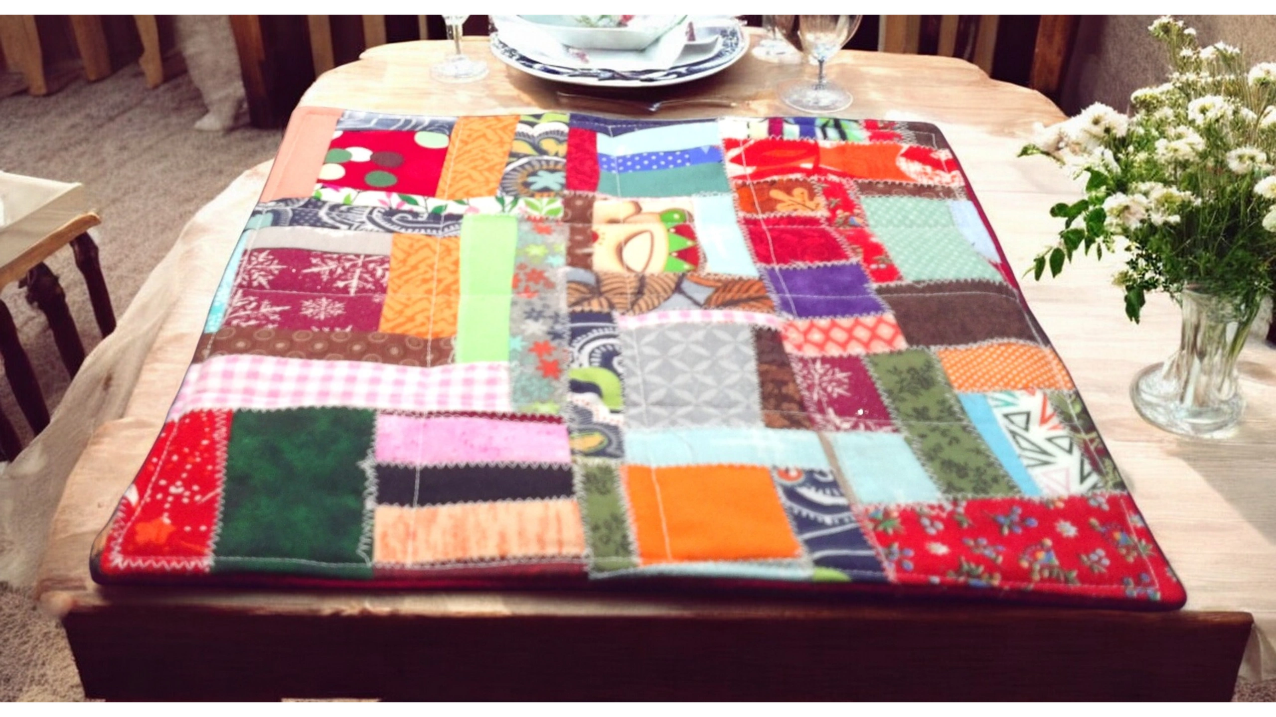 Patchwork quilt on dining table with colorful squares